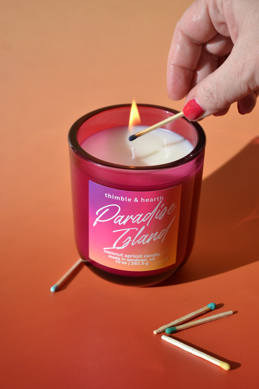 Hand-poured Paradise Island candle in a vivid cerise pink container, a tropical citrus and coconut scented candle by Thimble