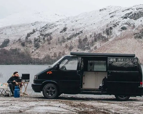 Small campervan conversion parked outdoors in a mountain setting