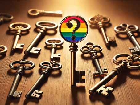 One key with a rainbow and question mark design stands up amongst a number of vintage metallic keys on a wooden surface