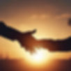 a close up silhouette of a man giving a helping hand to another man against the rising sun