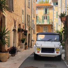Car driving through a narrow street in a traditional Provence village, illustrating the challenges of self-driving in the South of France
