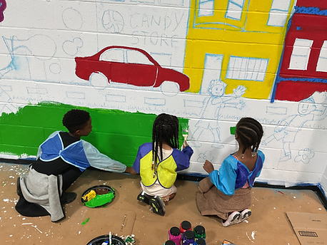 Campers painting green grass for our mural