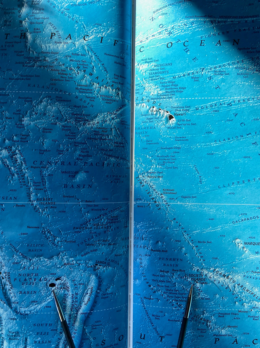 Knitting needles points to the artist’s respective destinations in the World Atlas; Fiji on the left, Tahiti on the right. Photo credit: Michelle Schwengel-Regala