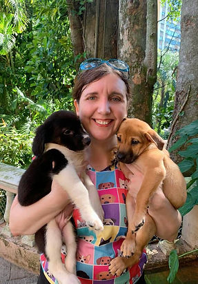 A woman, Dawn Carrington, holding two puppies
