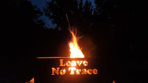 Campsite fire, with the message of "leave no trace".