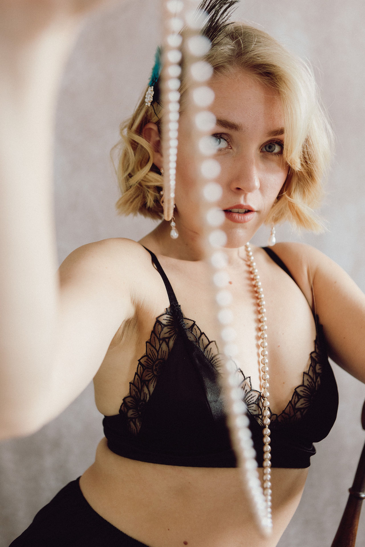 Elegant and artistic lingerie photoshoot with soft lighting and confident posing.