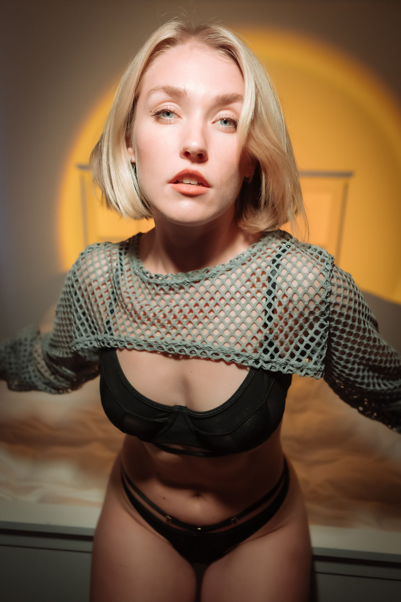 Elegant and artistic lingerie photoshoot with soft lighting and confident posing.