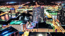 Aerial drone photograph of downtown Grand Rapids, MI at night, highlighting the city's illuminated skyline and urban landscap