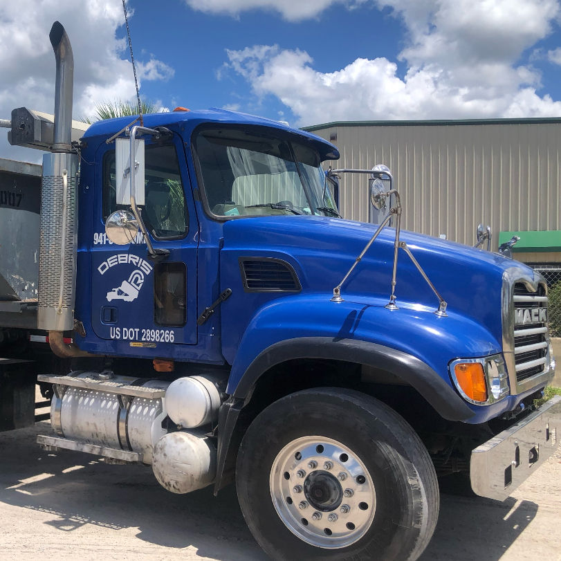 Debris R-US roll-off dumpster delivery truck serving Southwest Florida