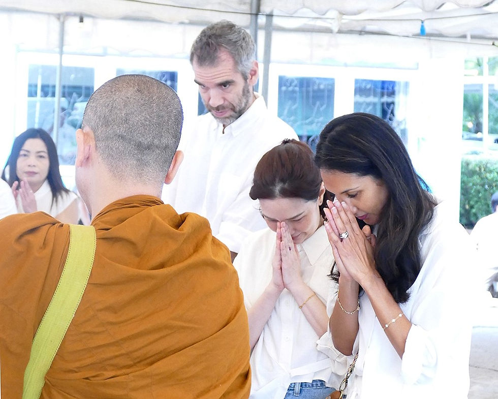 A photo from Thai Design's 50th anniversary Morning Ceremony - some of the team are pictured dress in white, paying their respects to a Buddhist monk