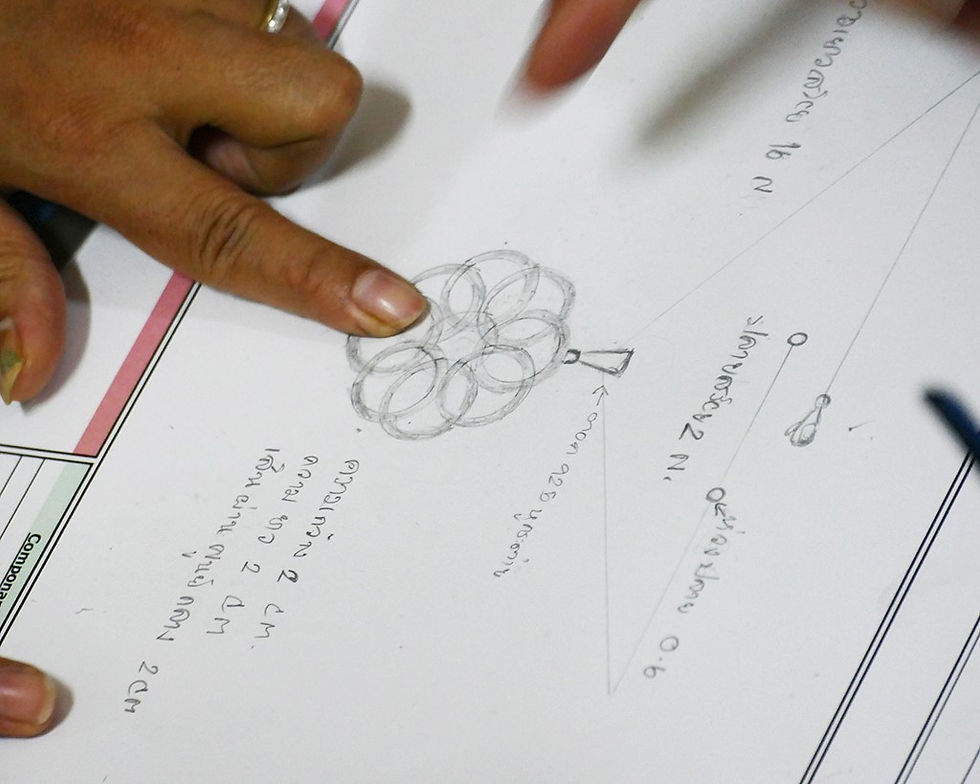 Behind the scenes, a labelled pencil sketch of a pendant design for the Thai Design jewellery design competition