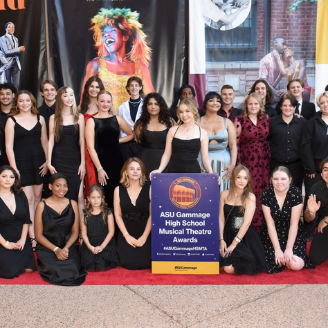 Chandler High School students stand in front of Broadway performance background.
