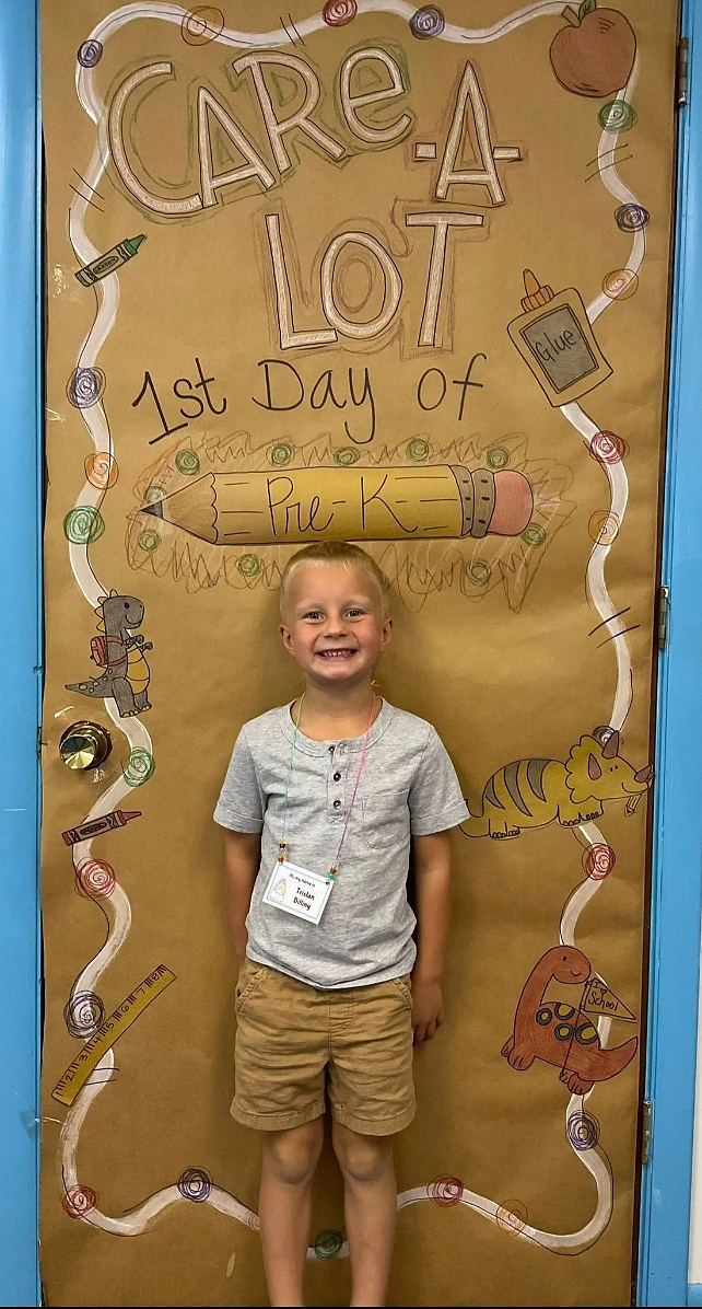 student standing in front of classroom door with Care-A-Lot decor