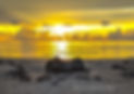 Half worn down sandcastle on the beach at sunrise