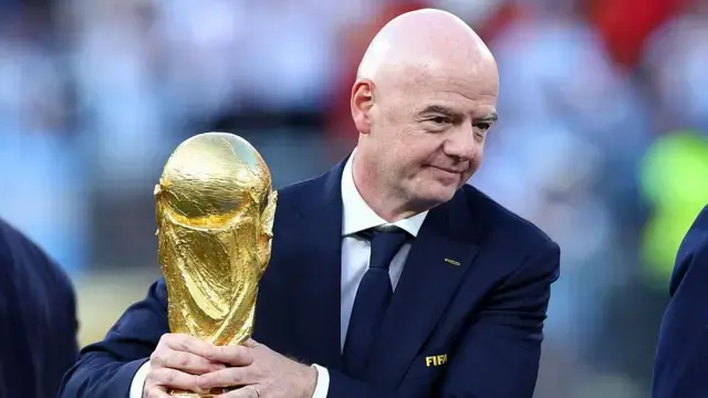 Gianni Infantino muestra la copa del mundo.