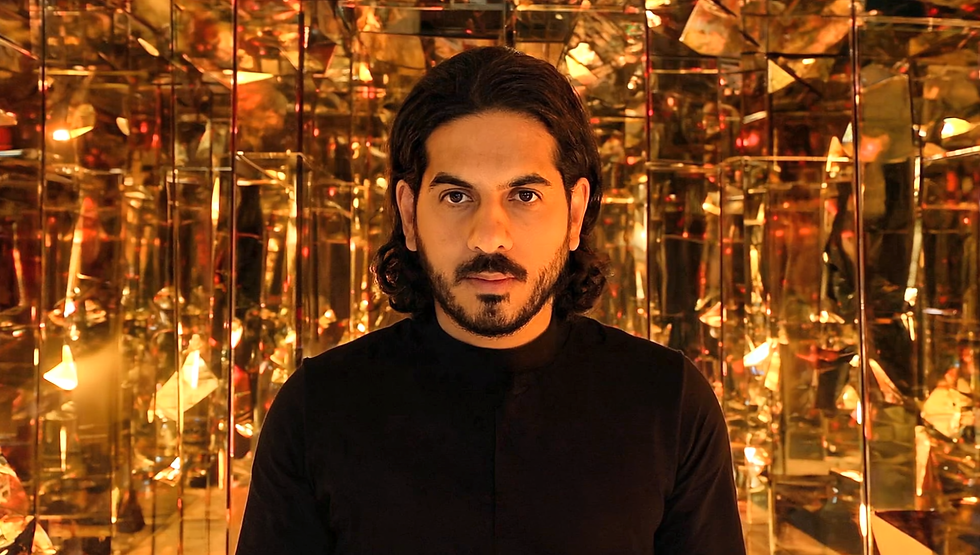 Gen4 centered man staring at the camera in a room full of mirrors and warm lighting colors