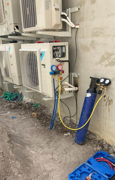 Climatiseurs en cours d'installation, outils et tuyaux. Max Elec, travaux en cours.