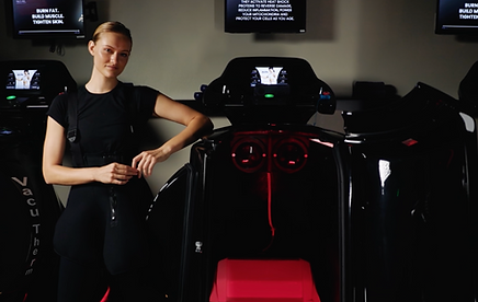 Client posing next to the VacuTherm Threadmill (Vacuum & Infrared light Therapy)