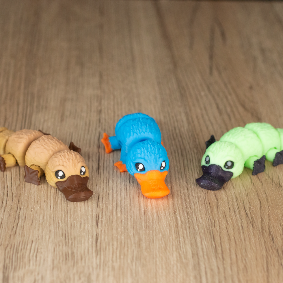 Brown, blue, and glow-in-the-dark green platypus toys.