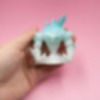 Hand holding a 3D printed ice elemental miniature, front view.