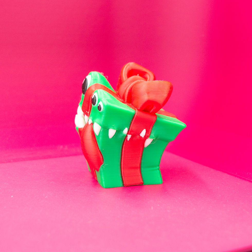 Thumbnail: Front view of the mimic Christmas present decoration with eyes, teeth, and tongue.