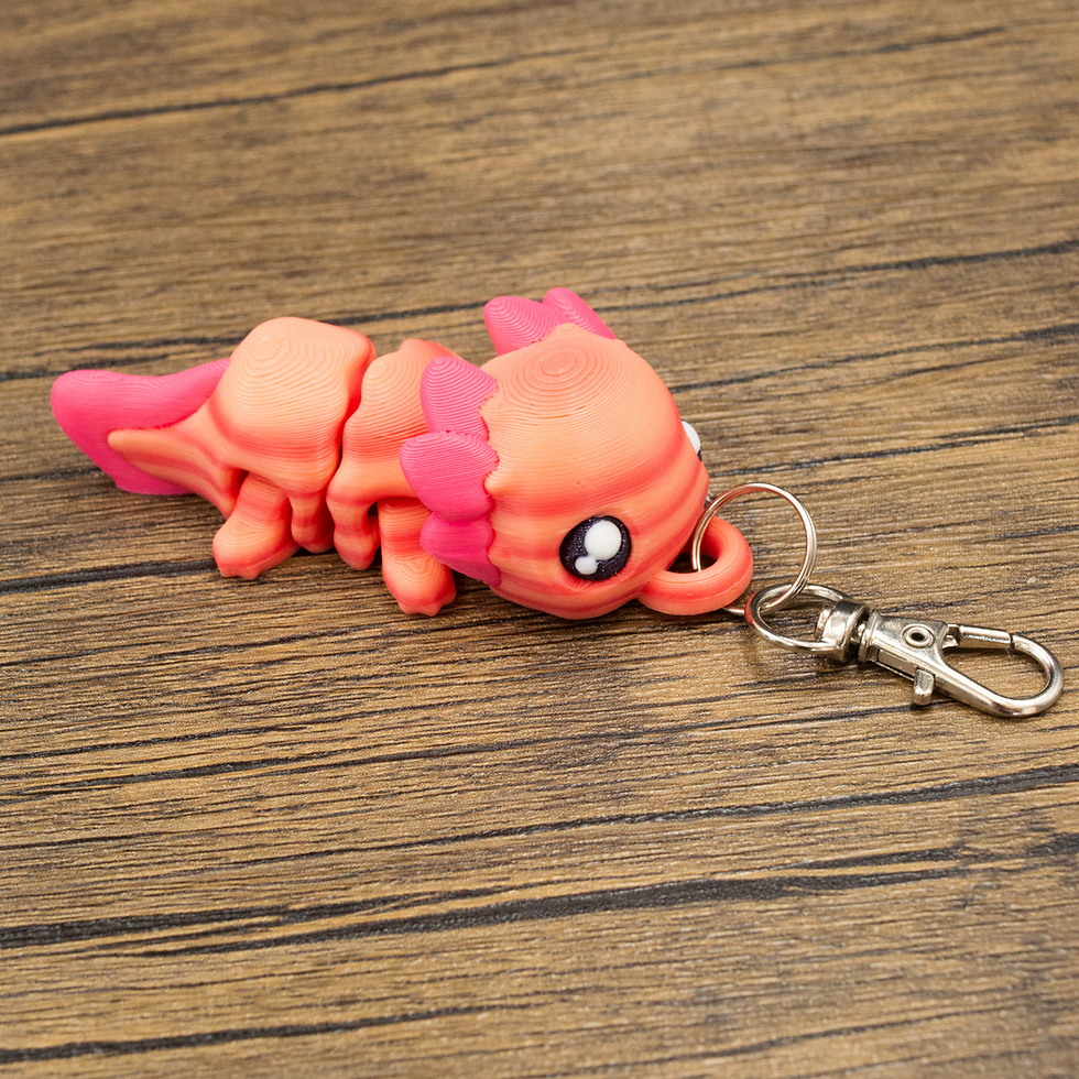 Thumbnail: Side view of axolotl keyring lying flat.