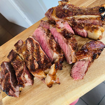 Pièce de bœuf cuite et découpée présentée sur une planche en bois