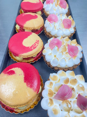 Assortiment de pâtisseries artisanales avec macarons garnis et tartelettes meringuées