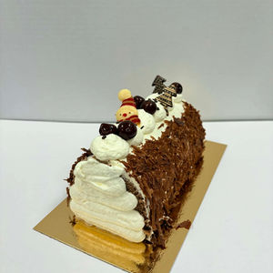 Bûche de Noël chocolat et crème décorée de copeaux de chocolat, chantilly et décors festifs, création artisanale de la Pâtisserie Engel.
