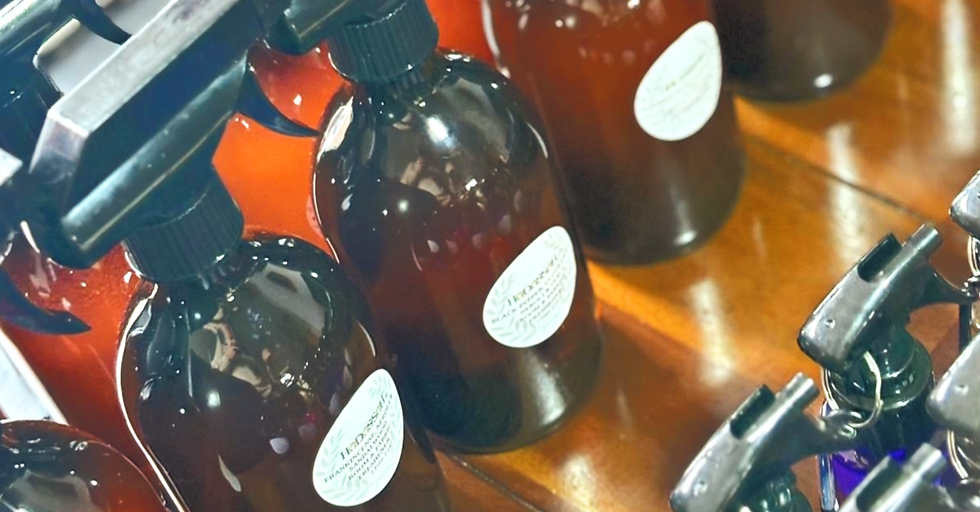 Eye-level view of essential oil bottles arranged on a wooden table