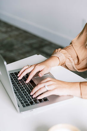 woman at computer hands light orange shirt.jpg