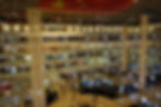 Spacious multi-level Louvre International Furniture mall interior with people walking on shiny floors. Large red flag above. Bright storefronts on each level.