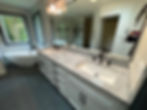 Master bathroom remodel in Snohomish, Washington featuring a double vanity with stone countertops, walk-in glass shower, freestanding soaking tub, and modern tile flooring as part of a whole house renovation.