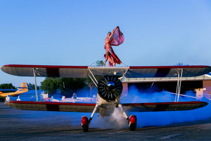 Ainhoa Sánchez realizando una acrobacia aérea sobre un biplano, simbolizando la toma de decisiones, el riesgo asumido y la acción en entornos aeronáuticos exigentes.