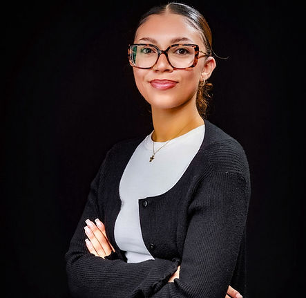 Young woman with glasses, folded arms and a black background. About Hodo Luxury Resort Apparel.