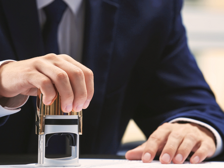 Businessperson stamping an official document, representing the approval process for obtaining a Certificate of Conformity (CoC) in Uzbekistan—a key requirement for regulatory compliance and market access