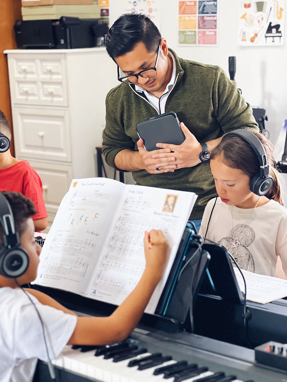 Piano teacher helping beginner students in Westchester group class