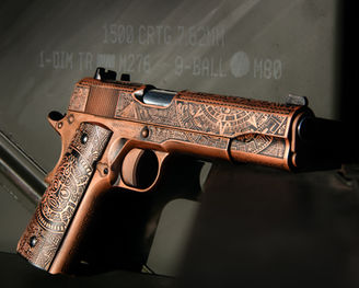 A Tisas 1911 that has been custom engraved with an Aztec theme and cerakoted a copper color.