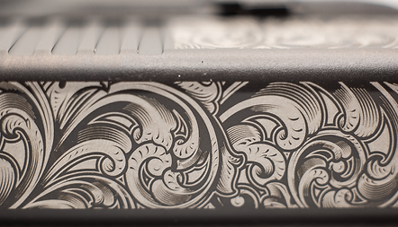 Shallow engraving of complex scrolls on Glock slide leaving bare metal as the final finish.