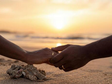 Couple holding hands on a beach symbolizing trust, support, and commitment in a relationship