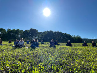 Amy Toft Yoga outside in a field with class
