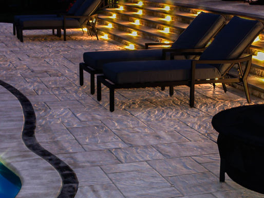 Pool patio with installed lights illuminating the area.