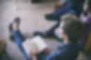Young people sitting on floor listening to speaker