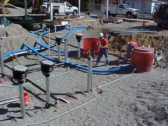 Gas station construction site showing new underground fuel lines and storage tank connections.