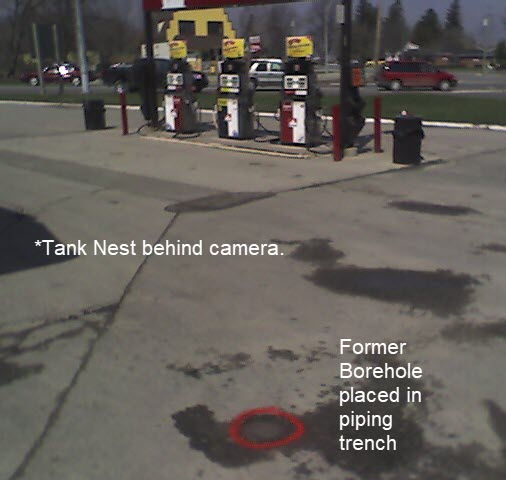 Former borehole drilled in gas station asphalt directly above piping trench, showing unsafe drilling practice.