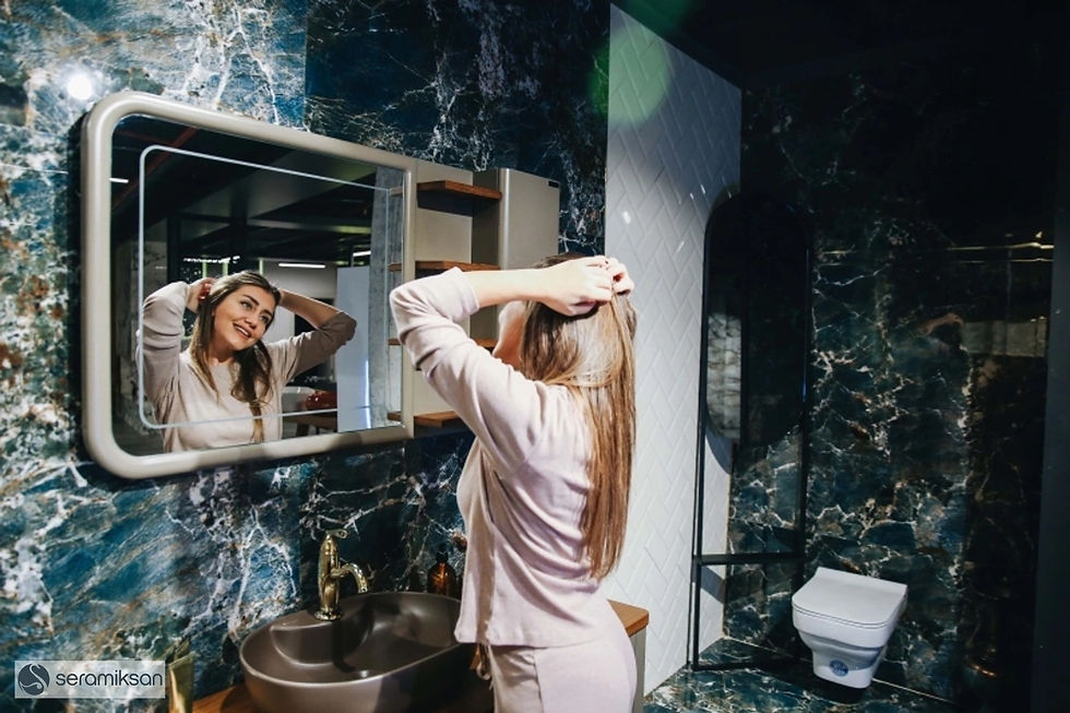 Femme se coiffant devant un miroir de salle de bain.