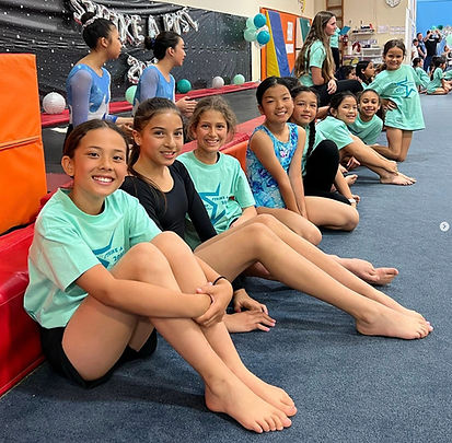 Smiling gymnastis students waiting for their turn.