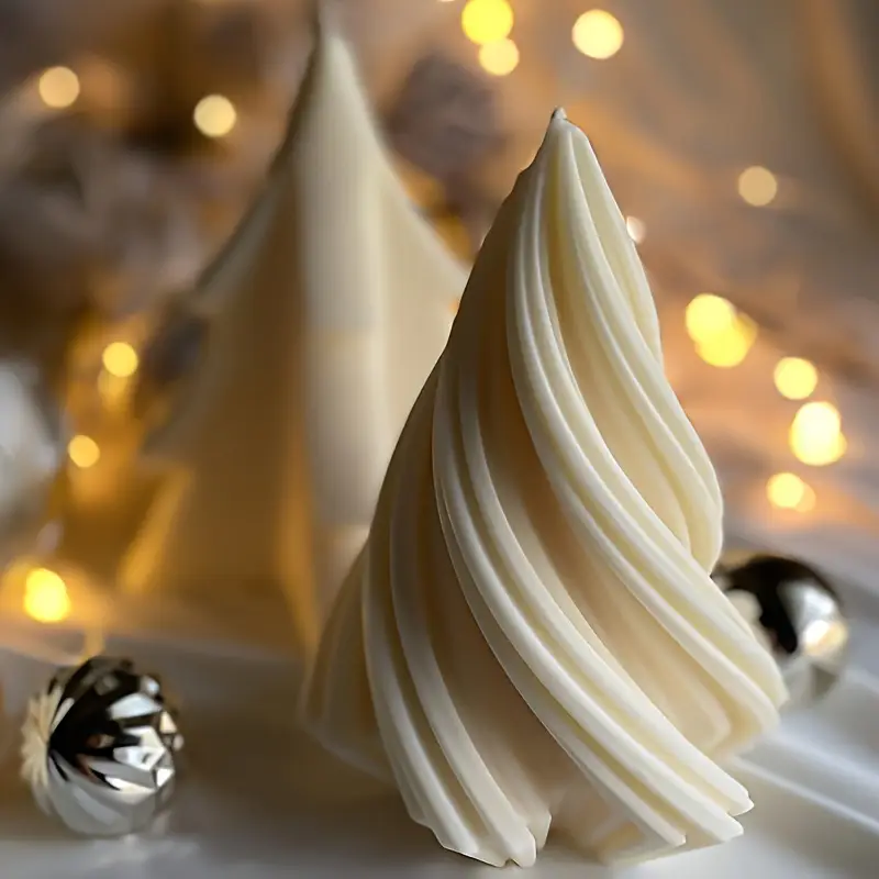 Decorative Christmas tree candles in white wax with warm fairy lights in the background.
