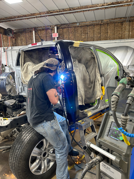 Technician welding on body frame