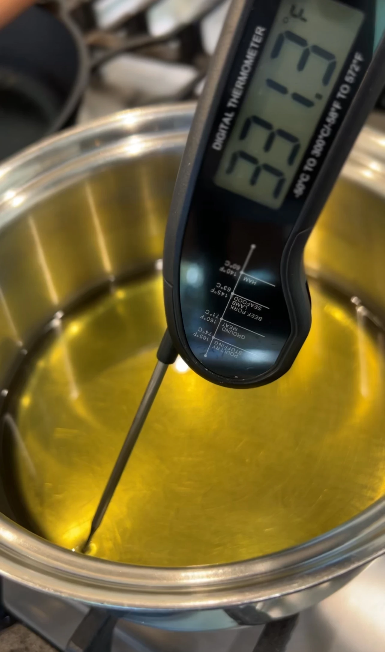 스텐솥안에 기름이 담겨져있고 온도계를 넣어 온도를 재고있다.